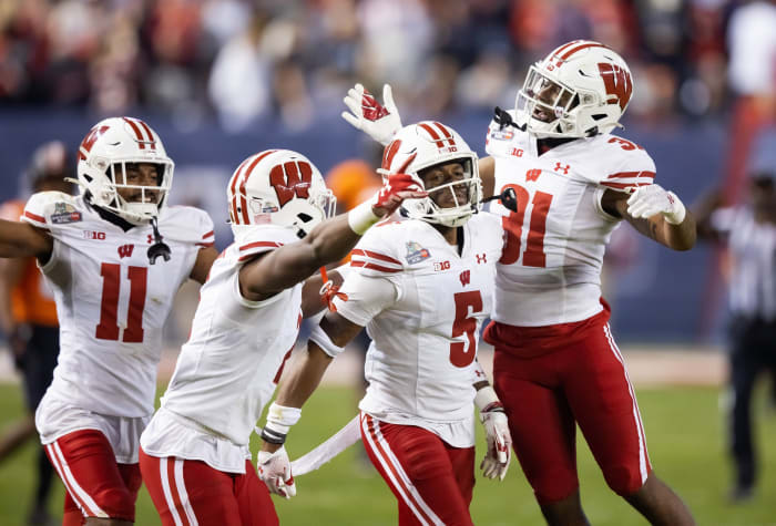 Dec 27, 2022; Phoenix, Arizona, USA; Wisconsin Badgers cornerback Cedrick Dort Jr. (5) celebrates with teammates after intercepting a pass against the Oklahoma State Cowboys in the second half of the 2022 Guaranteed Rate Bowl at Chase Field. Mandatory Credit: Mark J. Rebilas-USA TODAY Sports